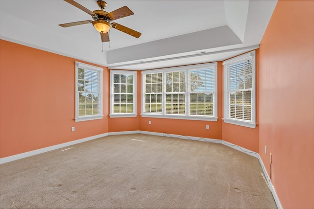 unfurnished room featuring baseboards, a ceiling fan, a healthy amount of sunlight, and light carpet