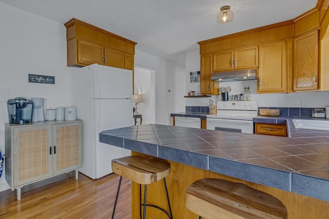 4058 Irvington Rd, Irvington, VA 22480 - kitchen with white appliances, sink, tile countertops, and kitchen peninsula