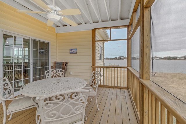 sunroom / solarium featuring ceiling fan and a water view