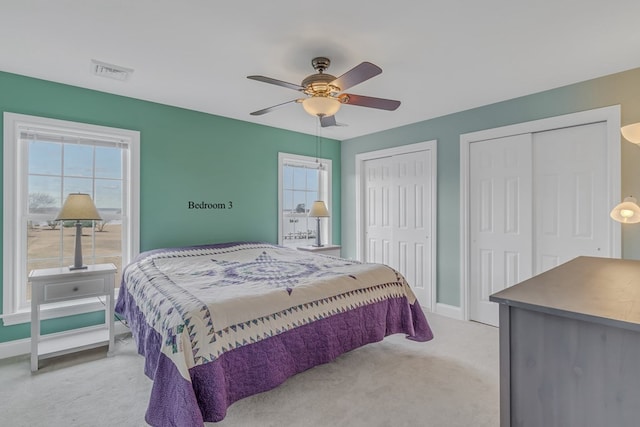 bedroom featuring ceiling fan and multiple closets