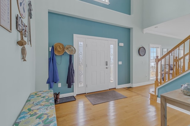 foyer featuring wood-type flooring and ornamental molding