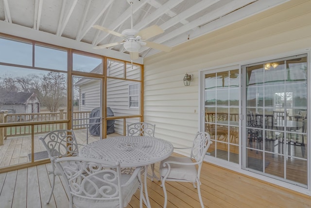 sunroom / solarium with beam ceiling and ceiling fan