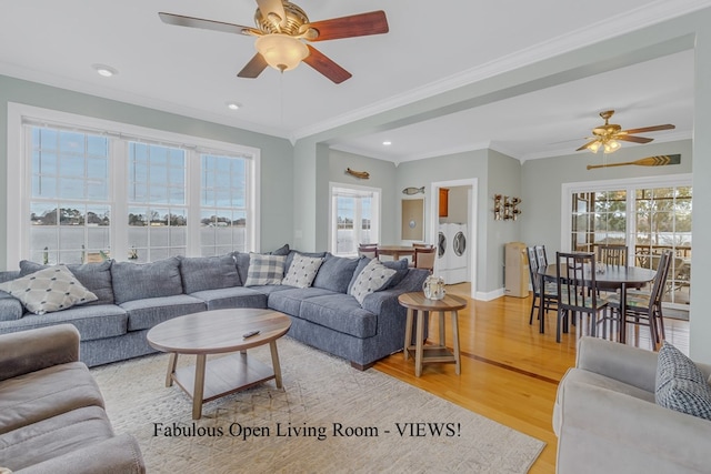 living room with ceiling fan, light wood-type flooring, separate washer and dryer, and ornamental molding