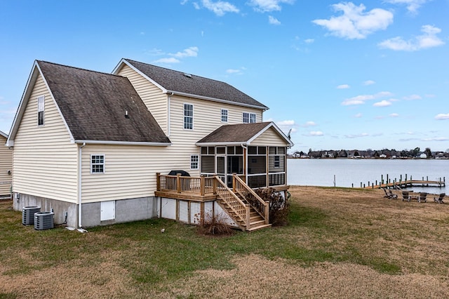 rear view of house with central AC, a sunroom, a yard, and a deck with water view