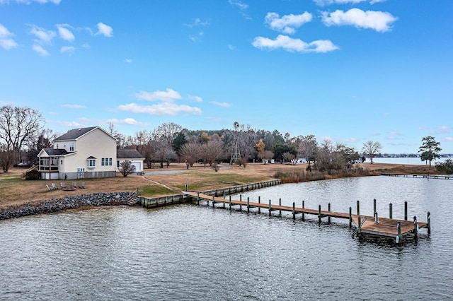 dock area with a lawn and a water view