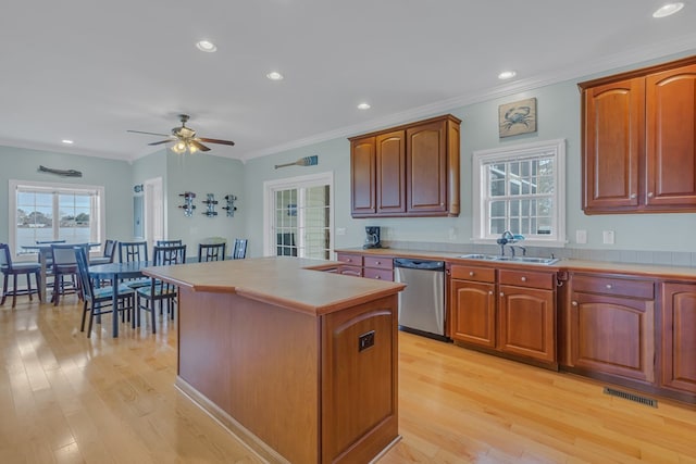 kitchen featuring sink, stainless steel dishwasher, ceiling fan, light wood-type flooring, and a kitchen island