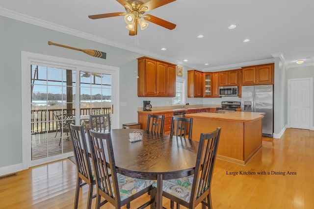 dining area featuring crown molding, ceiling fan, and light hardwood / wood-style floors