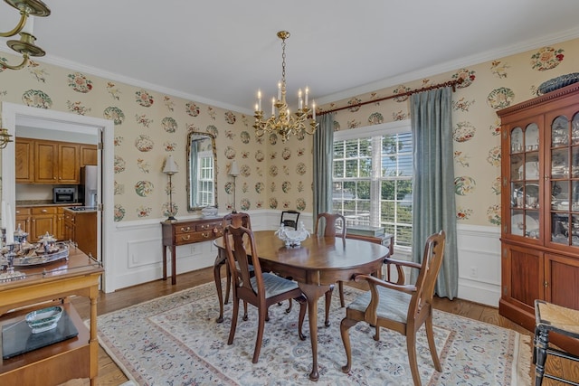 dining space with a chandelier, light hardwood / wood-style floors, and crown molding