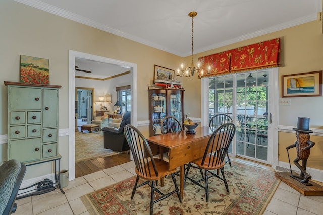 dining area with an inviting chandelier, crown molding, and light tile patterned flooring