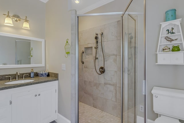 bathroom featuring ornamental molding, vanity, toilet, and a shower with shower door