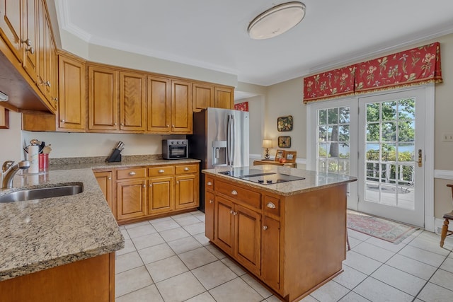 kitchen with light stone countertops, crown molding, sink, a center island, and light tile patterned flooring