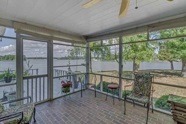 sunroom featuring ceiling fan, a water view, and a healthy amount of sunlight