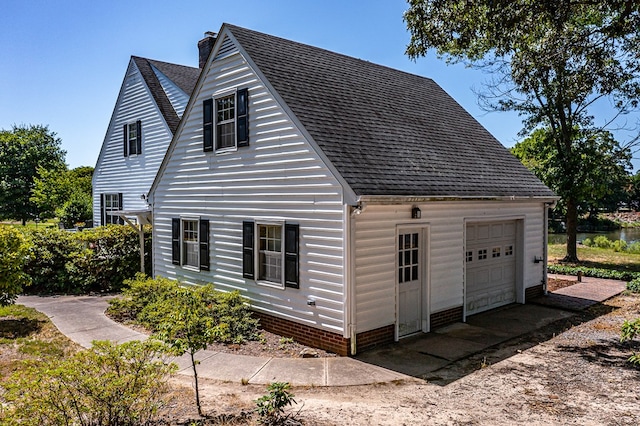 view of home's exterior with a garage and an outbuilding