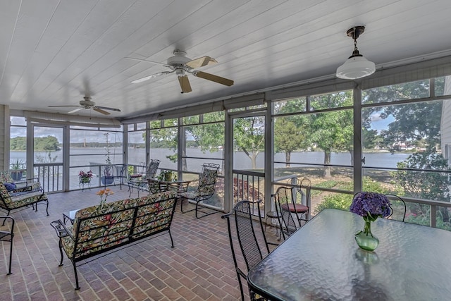 sunroom / solarium with ceiling fan, a water view, and wood ceiling