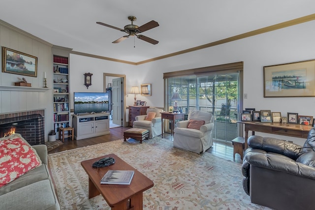 living room with built in shelves, ceiling fan, hardwood / wood-style flooring, a fireplace, and ornamental molding