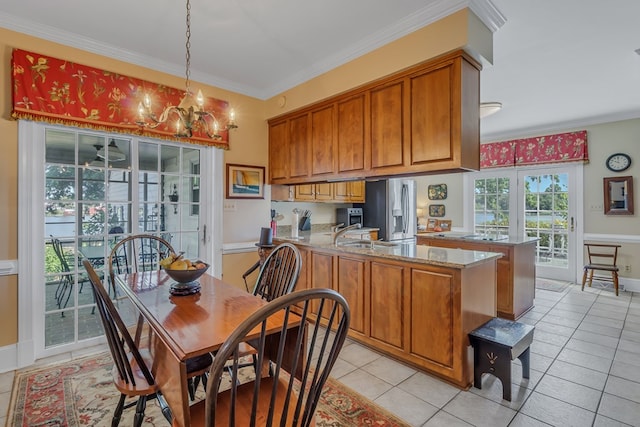 kitchen with stainless steel refrigerator with ice dispenser, decorative light fixtures, light tile patterned flooring, light stone counters, and kitchen peninsula