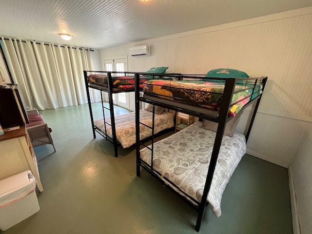 bedroom featuring concrete flooring, french doors, and a wall mounted AC