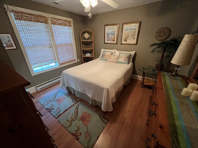 bedroom featuring hardwood / wood-style floors, a baseboard radiator, and ceiling fan