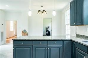 525 Main St, Mathews, VA 23109 - kitchen with light countertops, a peninsula, an inviting chandelier, and pendant lighting