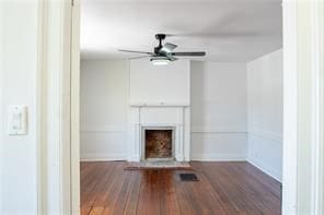 525 Main St, Mathews, VA 23109 - unfurnished living room featuring baseboards, ceiling fan, a fireplace with raised hearth, and wood finished floors