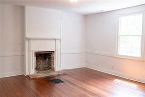 525 Main St, Mathews, VA 23109 - unfurnished living room with visible vents, baseboards, wood finished floors, and a fireplace
