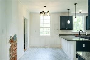 525 Main St, Mathews, VA 23109 - kitchen with decorative light fixtures, dark countertops, a sink, a chandelier, and ornamental molding