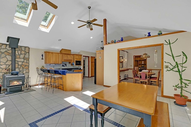 10114 New Hope Ct, Gloucester, VA 23061 - kitchen with lofted ceiling, a ceiling fan, a peninsula, light tile patterned flooring, and a wood stove