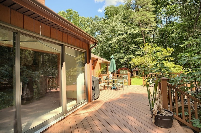 10114 New Hope Ct, Gloucester, VA 23061 - wooden deck featuring a storage shed, outdoor dining space, and view of scattered trees