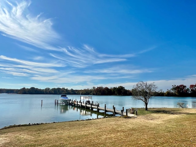 view of dock featuring a lawn and a water view