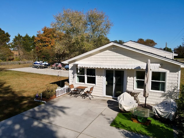 back of property featuring a patio area and a yard