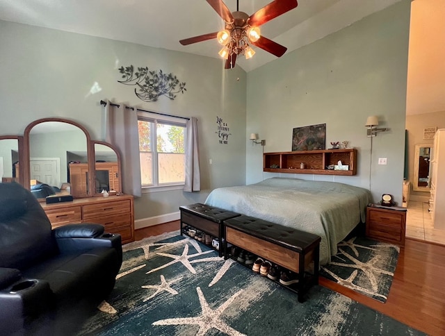 bedroom with hardwood / wood-style floors, vaulted ceiling, and ceiling fan