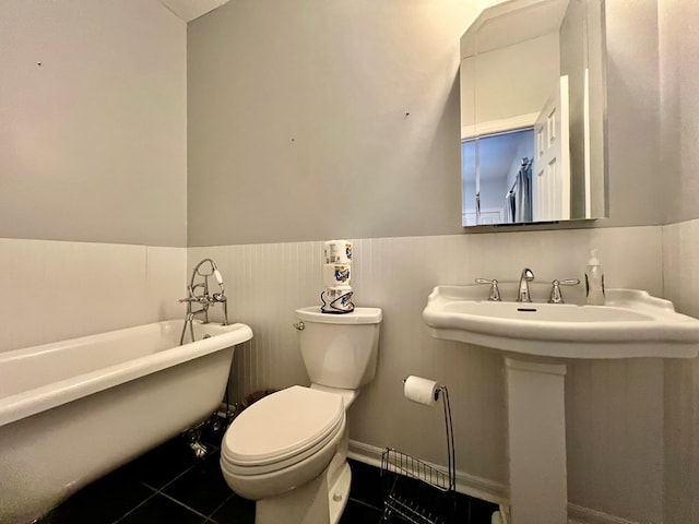 bathroom with tile patterned flooring, toilet, and a bath