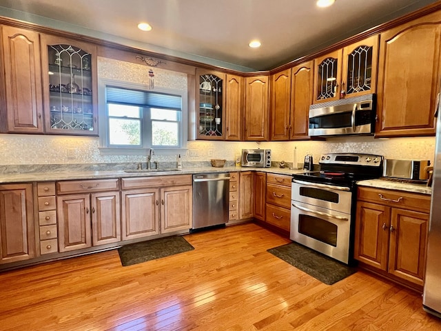 kitchen featuring sink, light hardwood / wood-style flooring, and appliances with stainless steel finishes