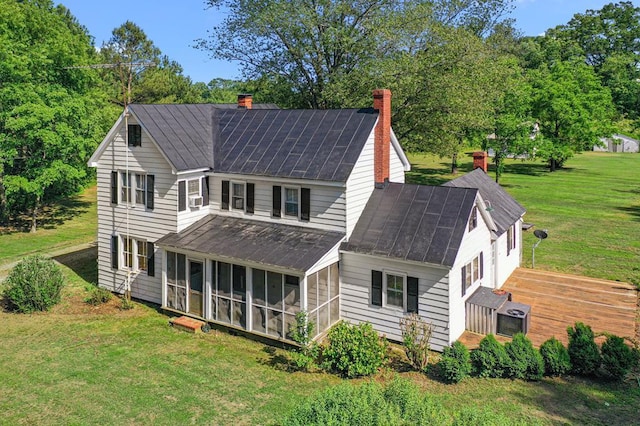 1838 Muddy Gut Rd, Dunnsville, VA 22454 - rear view of property featuring a sunroom, a chimney, a yard, and metal roof