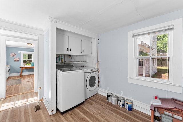 1838 Muddy Gut Rd, Dunnsville, VA 22454 - laundry room featuring cabinet space, washing machine and dryer, light wood-style floors, and baseboards