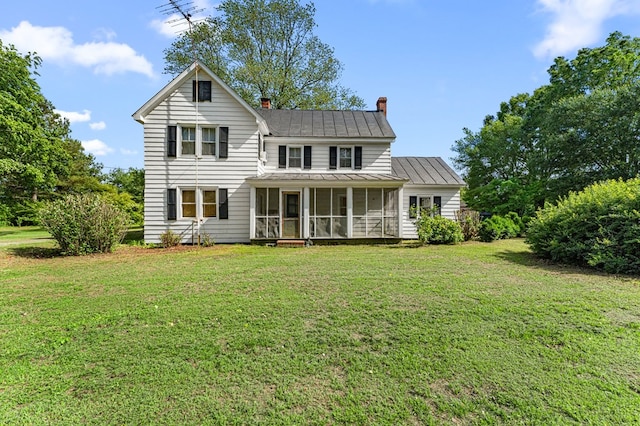 1838 Muddy Gut Rd, Dunnsville, VA 22454 - back of property with a sunroom, a chimney, a yard, a metal roof, and a standing seam roof