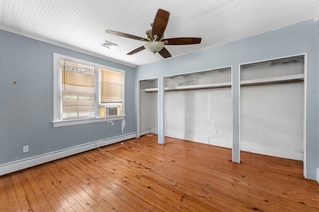 1838 Muddy Gut Rd, Dunnsville, VA 22454 - unfurnished bedroom with a baseboard radiator, two closets, baseboards, wood-type flooring, and cooling unit