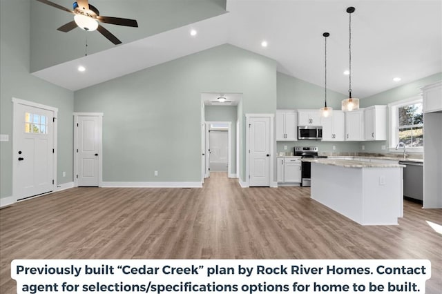 kitchen with stainless steel appliances, decorative light fixtures, a kitchen island, and white cabinets