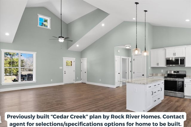 kitchen featuring appliances with stainless steel finishes, decorative light fixtures, a center island, and white cabinets