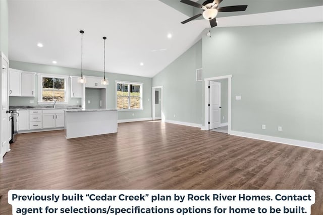 unfurnished living room featuring ceiling fan, dark wood-type flooring, sink, and high vaulted ceiling