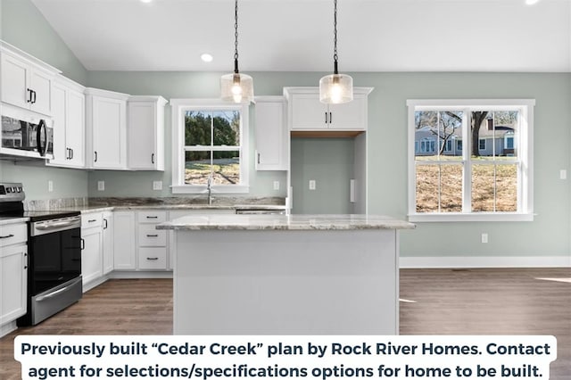 kitchen with pendant lighting, appliances with stainless steel finishes, light stone countertops, and a kitchen island