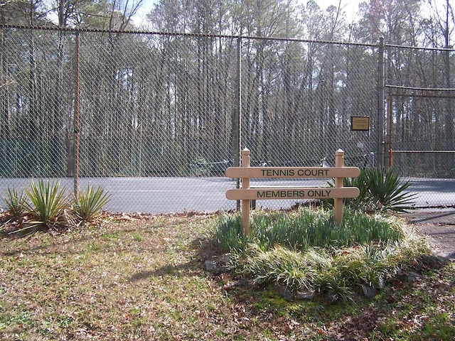 view of home's community featuring tennis court