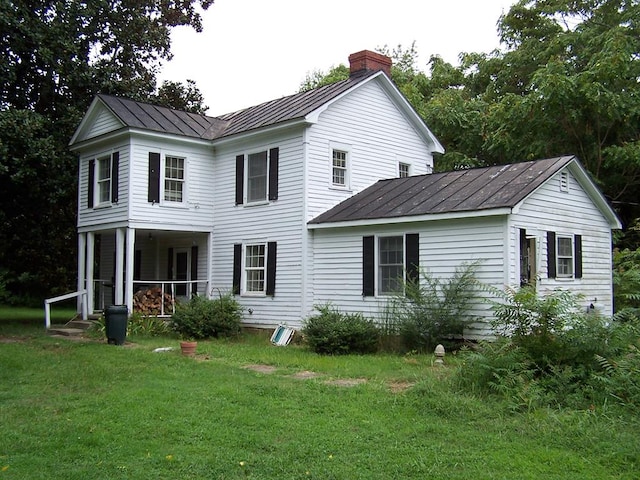 rear view of house with a yard and covered porch