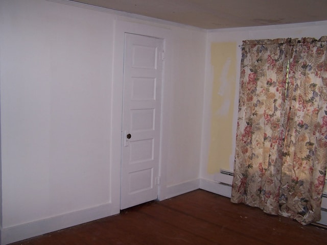 unfurnished room featuring dark wood-type flooring and crown molding