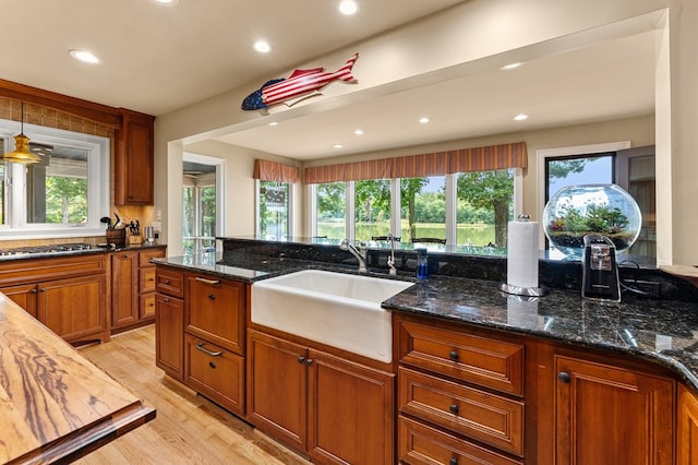 873 Deep Creek Rd, Lancaster, VA 22503 - kitchen featuring a sink, light wood-type flooring, brown cabinetry, dark stone counters, and recessed lighting