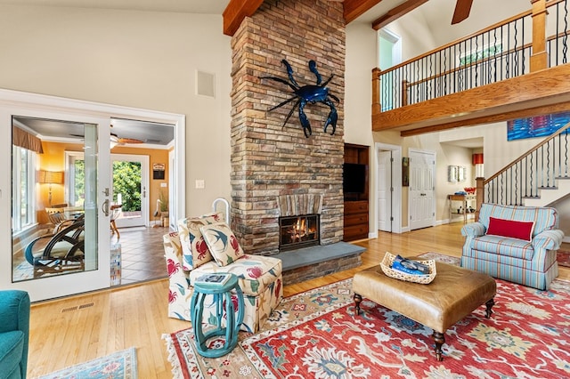 873 Deep Creek Rd, Lancaster, VA 22503 - living room featuring high vaulted ceiling, stairway, wood finished floors, a fireplace, and beam ceiling