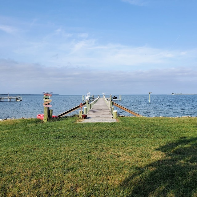 dock area with a yard and a water view