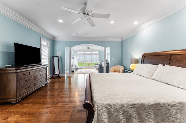 bedroom with dark hardwood / wood-style flooring, ornate columns, ceiling fan, and crown molding