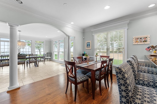 tiled dining area featuring decorative columns, an inviting chandelier, and ornamental molding