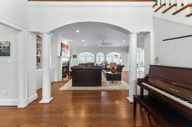 interior space featuring hardwood / wood-style floors, ornate columns, ceiling fan, and ornamental molding